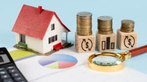 Financial planning concept with house model, coins, and graphs representing buying property in Bali.