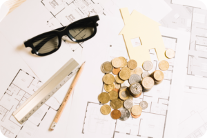 Coins on architectural plans symbolizing Passive Income Property Investments with Coco Development Group.