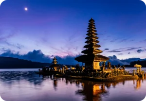 A serene evening view of Ulun Danu Beratan Temple reflecting on a lake in Bali, illustrating the scenic charm highlighted by Coco Development Group in their Bali travel tips.