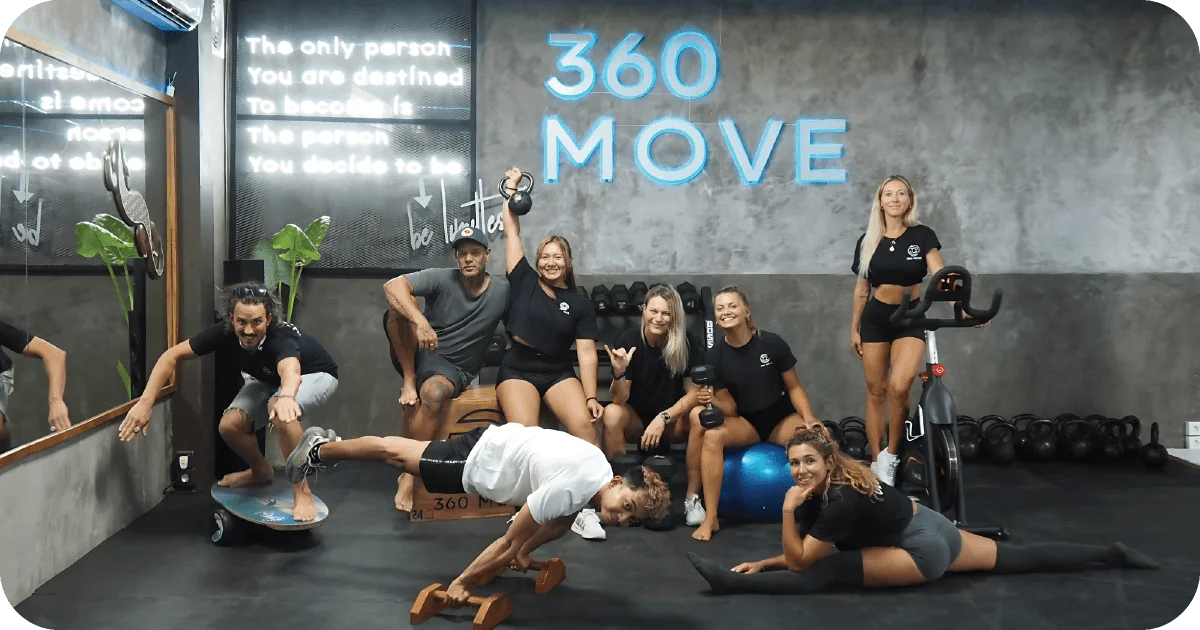 360 MOVE team posing in studio with kettlebells and spin bike