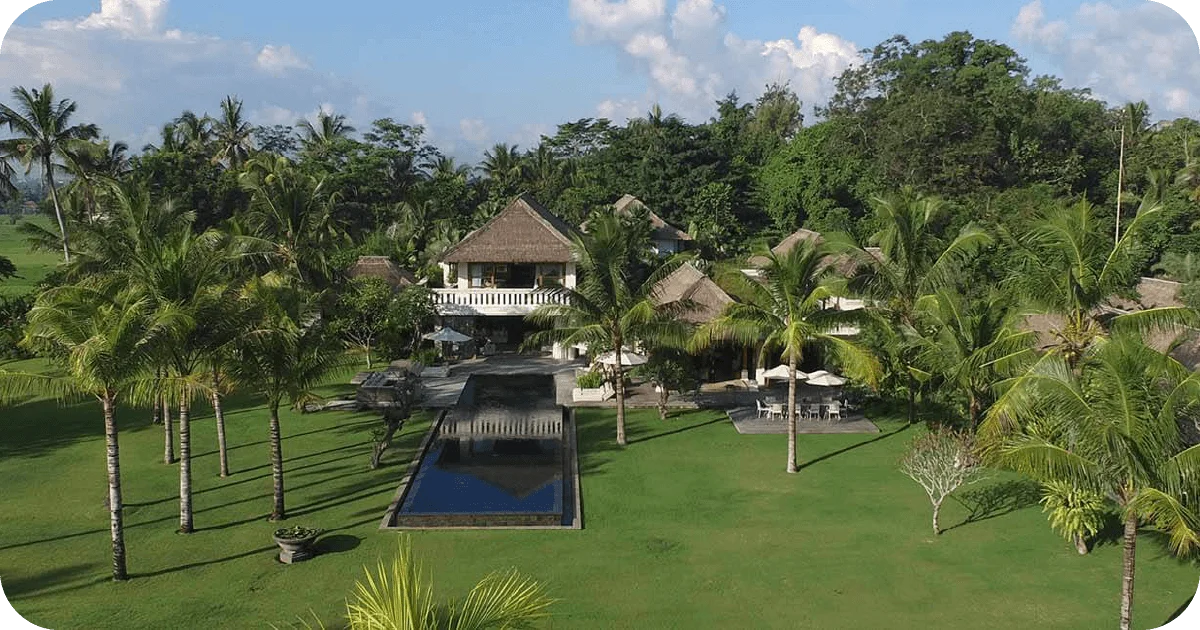 Aerial view of tropical villa estate with central lap pool and palms