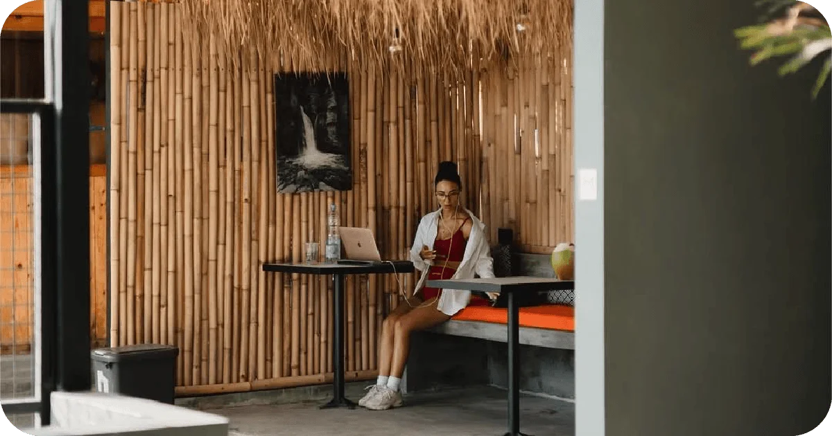 Bamboo-walled lounge with seating, laptop and drink near gym