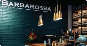 Barbarossa bar counter with gold pendant lights and bottle display
