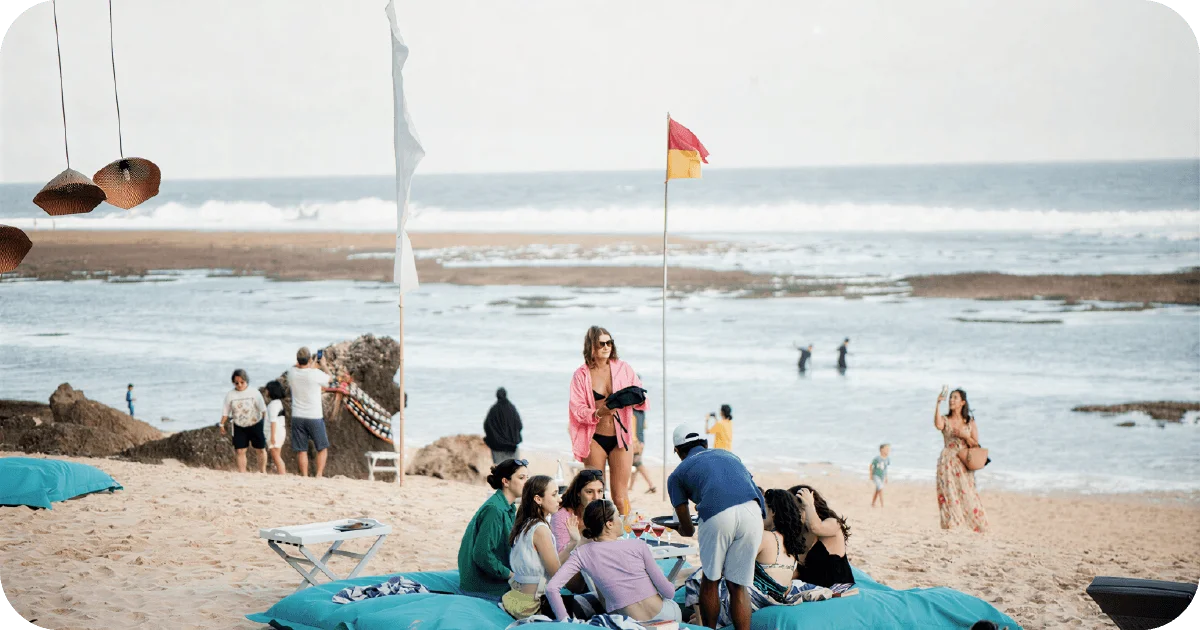 Beach club beanbags around low table with shoreline views and flags