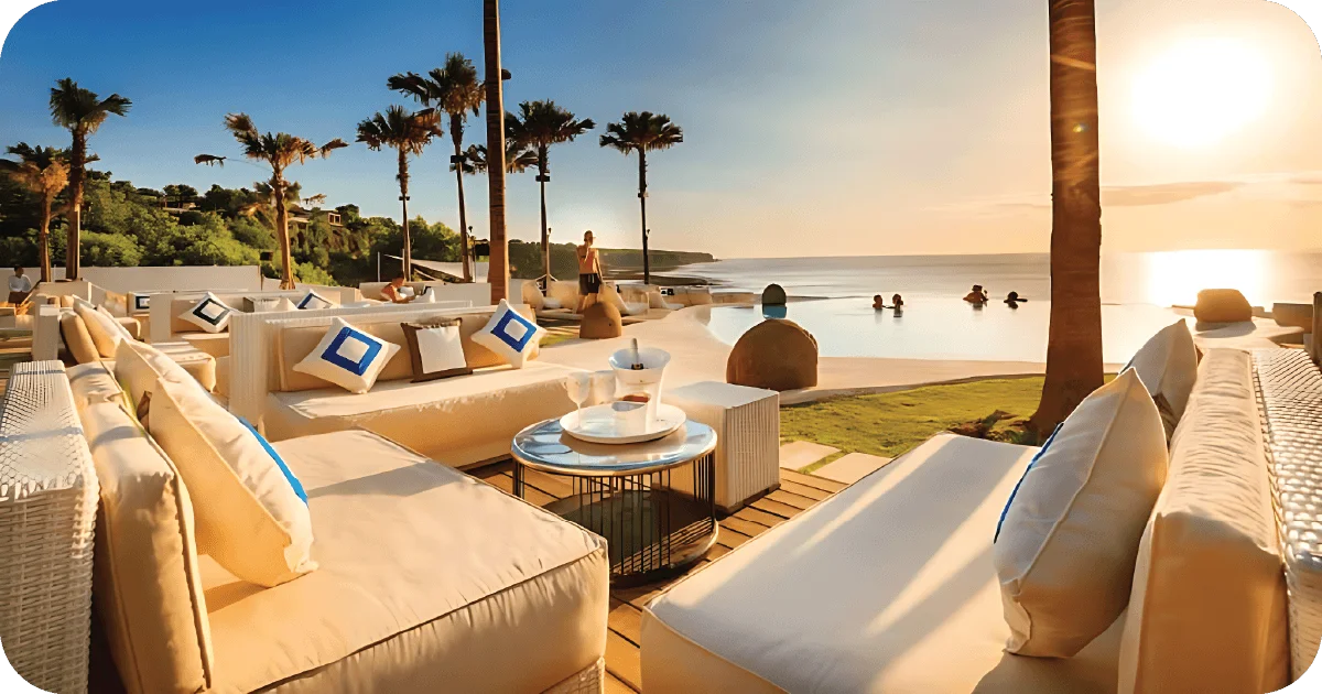 Beachfront lounge sofas facing infinity pool at sunset