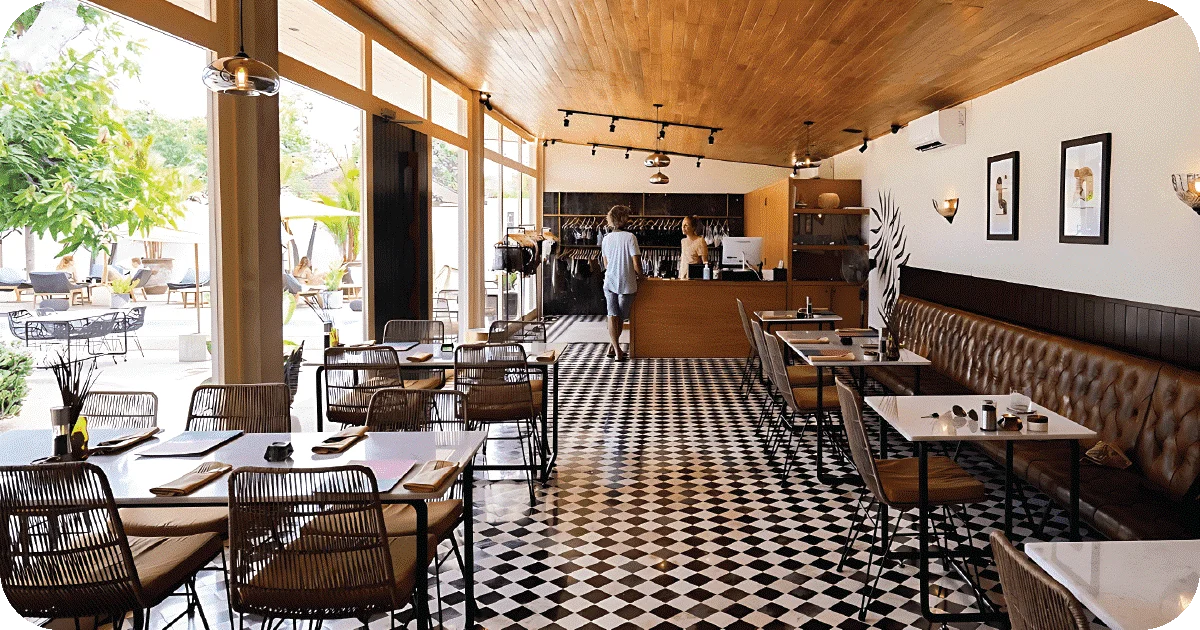 Bright dining room with checkered floor, rattan chairs, open patio views