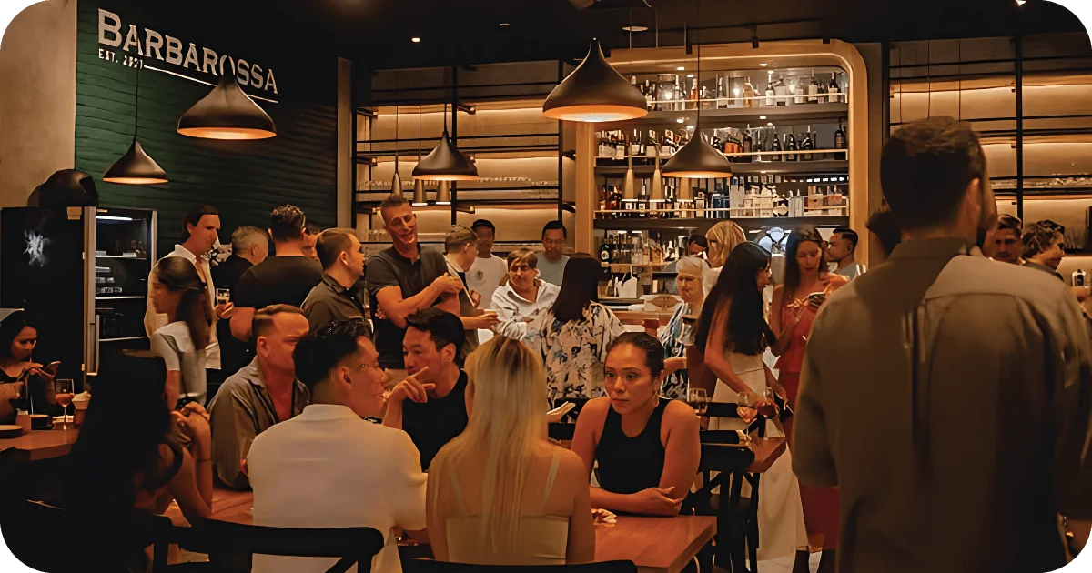Busy Barbarossa dining room with pendant lights and open bar shelving