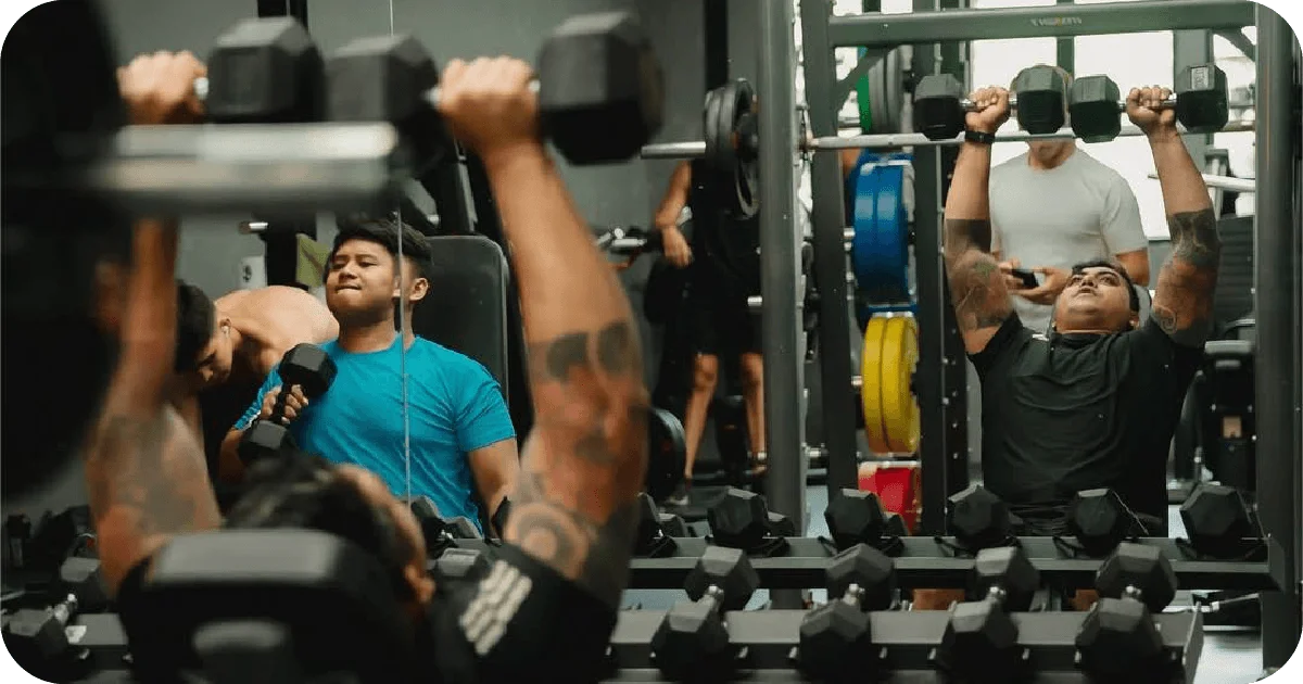 Busy free weights zone with seated dumbbell presses and plates