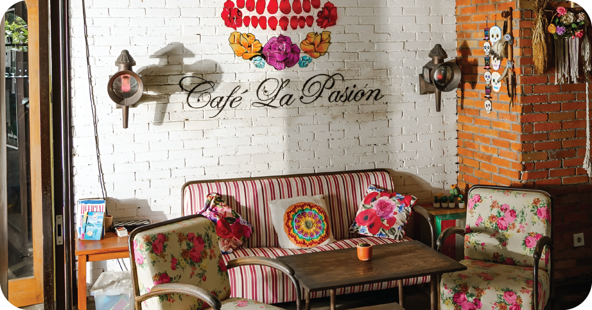 Café La Pasión lounge with striped sofa, floral chairs, candlelit table