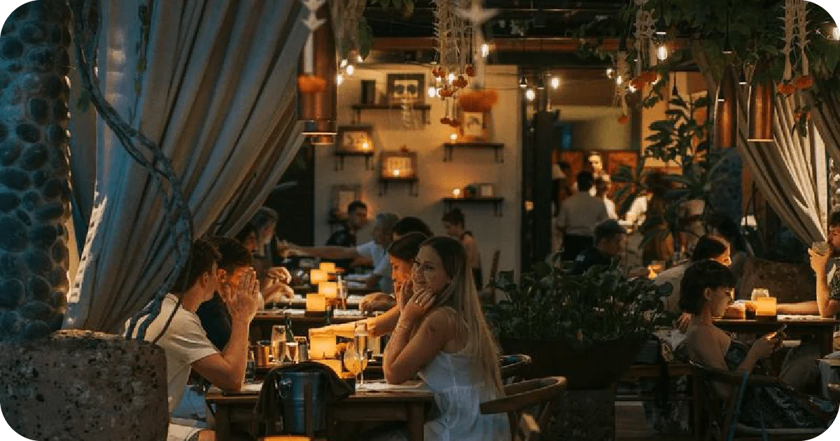 Candlelit dining room with draped curtains and hanging plants