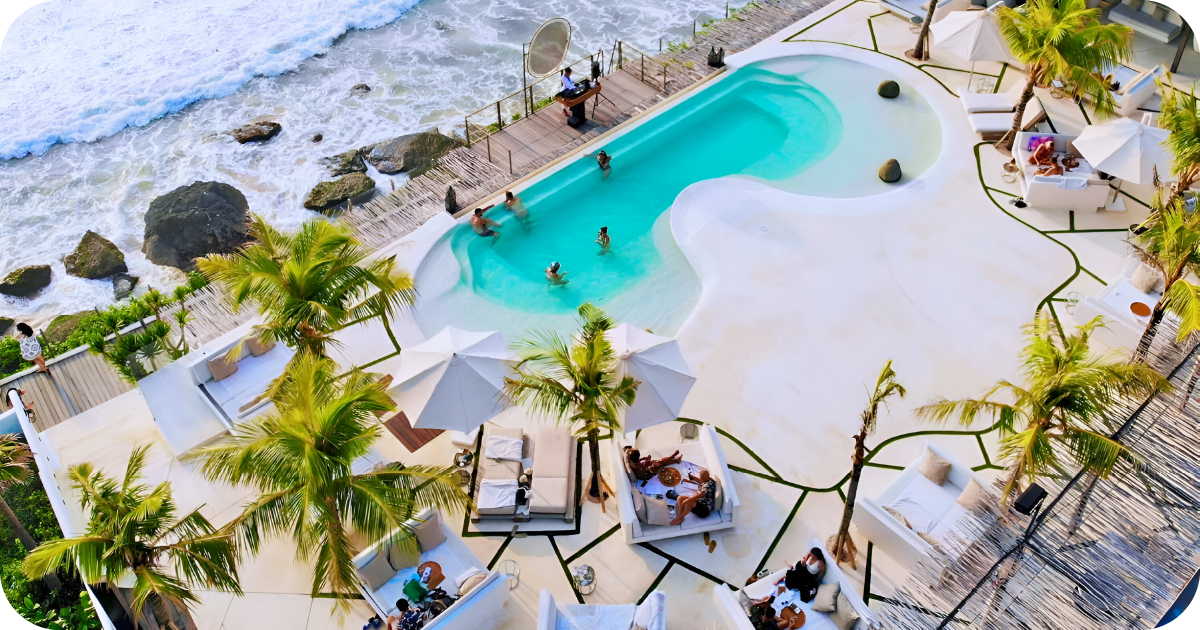 Cliffside beach club with pool, daybeds, umbrellas, ocean waves