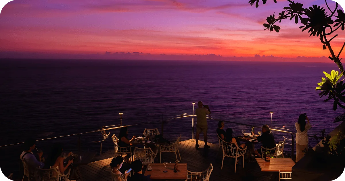 Cliffside deck dining at sunset overlooking the sea