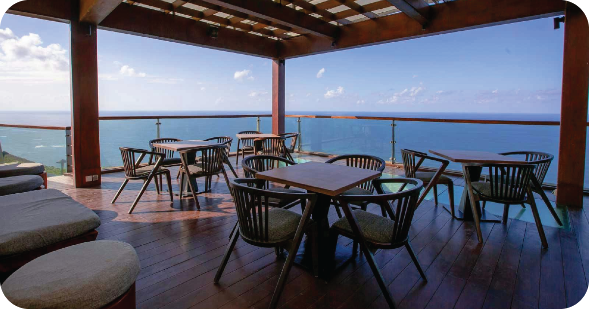 Cliffside rooftop patio with ocean views and glass railing