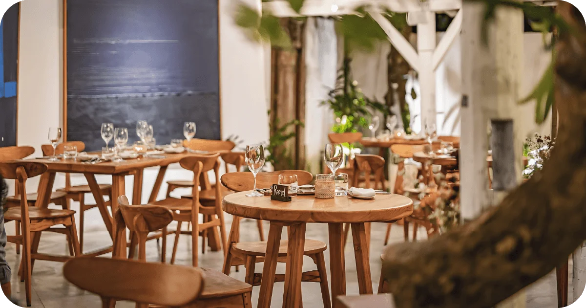 Cozy interior with set wooden tables, wine glasses, and art