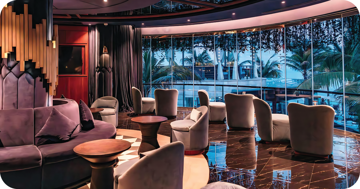 Curved lounge with plush chairs and floor-to-ceiling windows