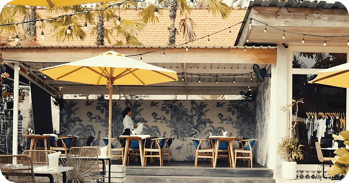 Daytime terrace with yellow umbrellas, mural wall, wooden chairs