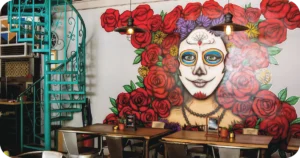 Dining room with Calavera rose mural and turquoise spiral staircase