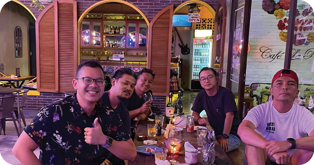 Friends at indoor table beside bar; Café La Pasión sign behind