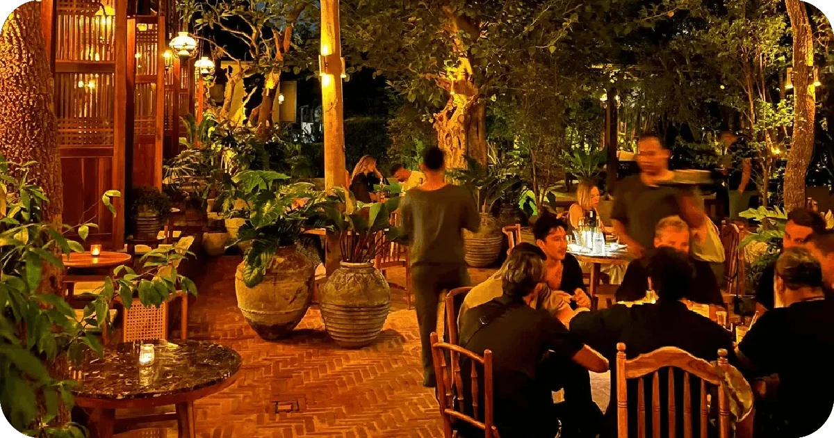 Garden patio at night with potted trees and warm lighting