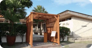 Gooseberry entrance with wooden pergola host stand and stone facade