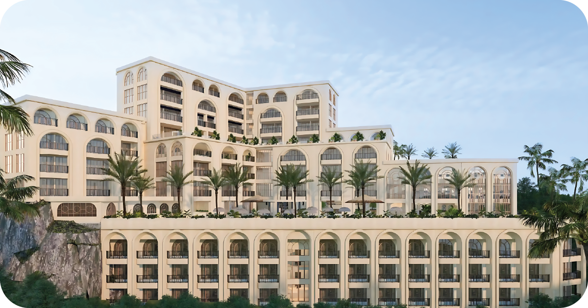 Grand hillside hotel with arched balconies and palm trees