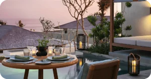 Intimate poolside table setting with candles and ocean backdrop