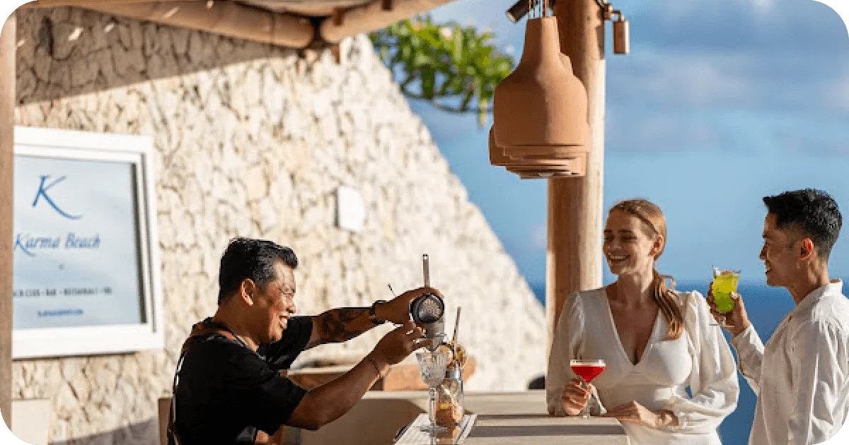 Karma Beach bar; bartender pouring cocktails for two guests