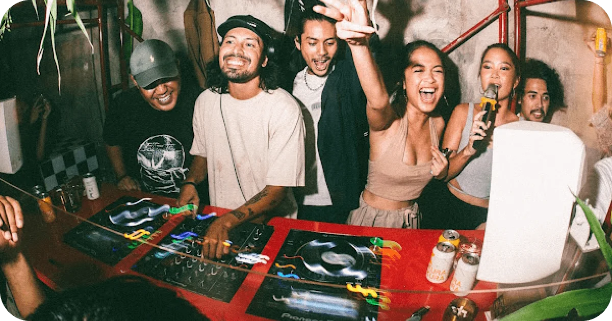 Lively DJ booth with cheering crowd, Pioneer decks, and canned beers