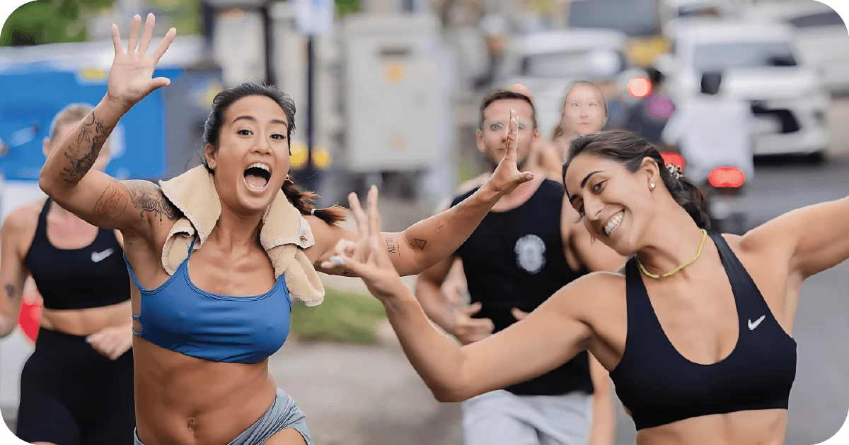Members on community run outside, smiling and high-fiving