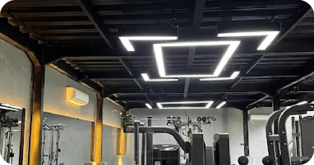 Modern gym with geometric LED ceiling lights and strength machines