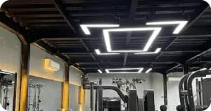 Modern gym with geometric LED ceiling lights and strength machines