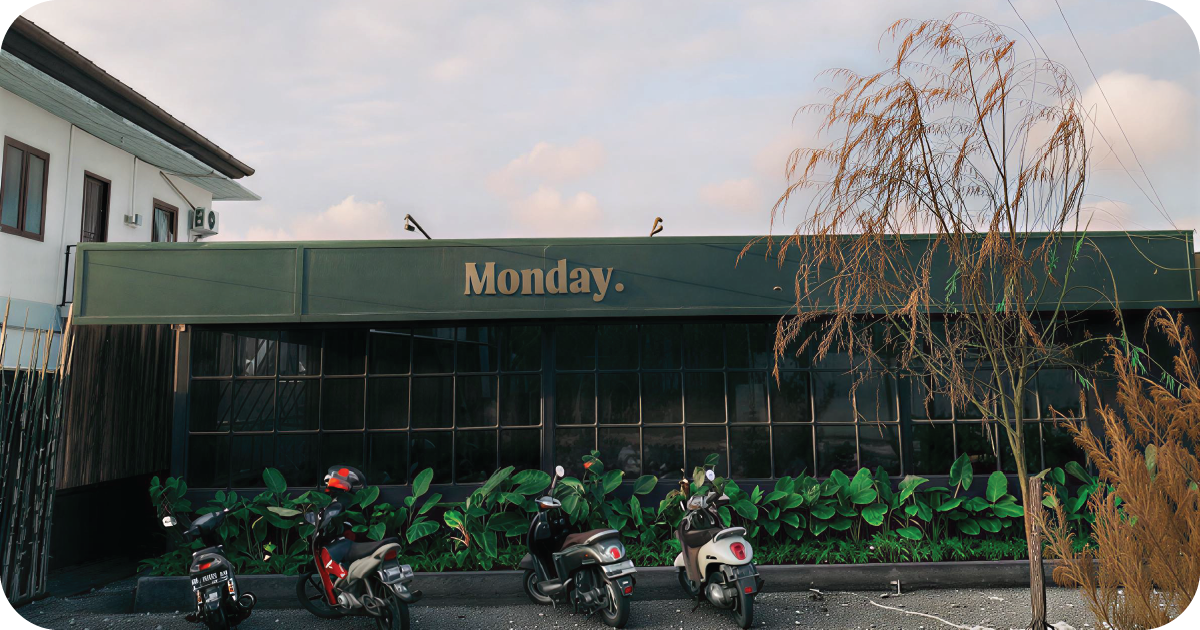 Monday cafe exterior with scooters and lush street landscaping