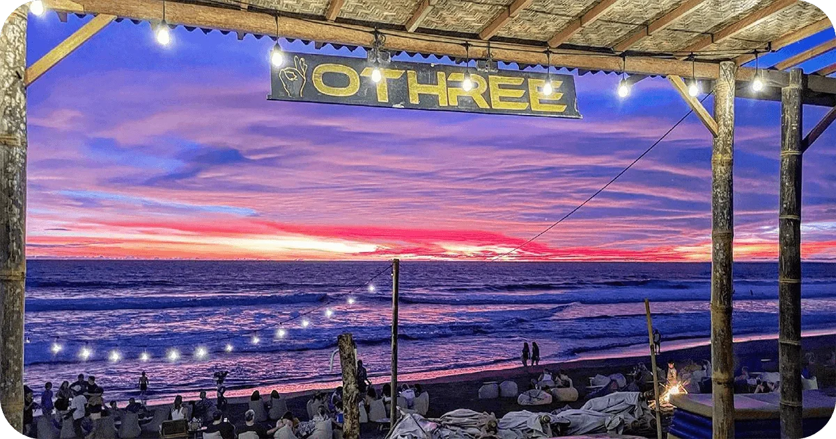 OTHREE sign over vivid sunset and waves at beachfront bar