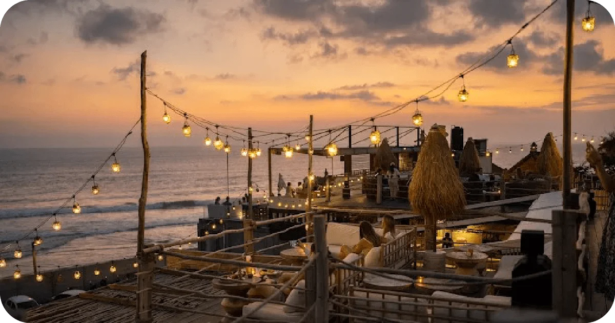 Oceanfront rooftop at sunset with dangling string lights