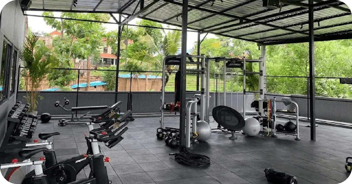 Open-air functional area with spin bikes, dumbbells, cables and battle ropes