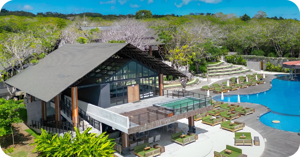 Open-air poolside restaurant with infinity pool and green daybeds