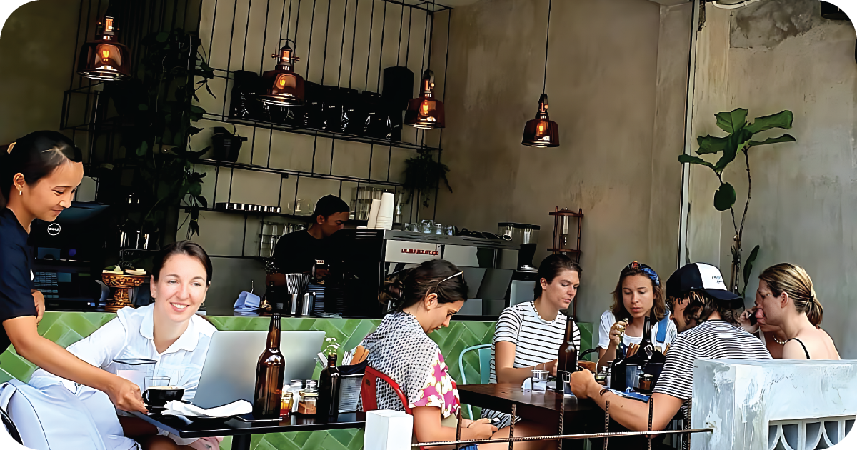 Open coffee bar with La Marzocco machine and hanging pendant lights