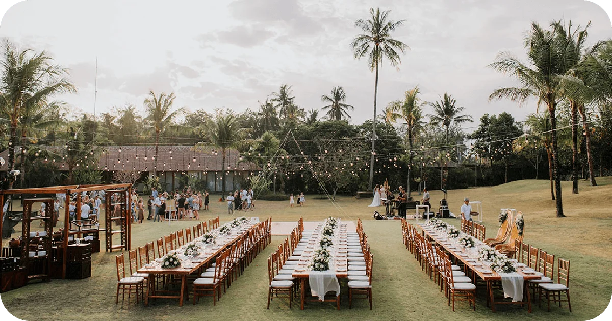 Outdoor reception setup with string lights and long dining tables