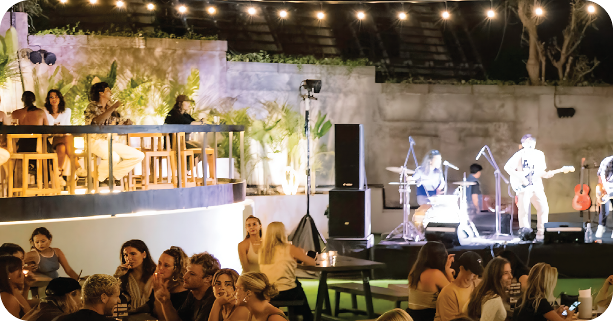 Outdoor stage with string lights, live band, and tiered seating