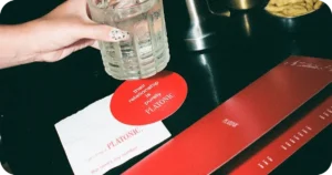 PLATONIC coaster and red menu beside a frosty rocks glass