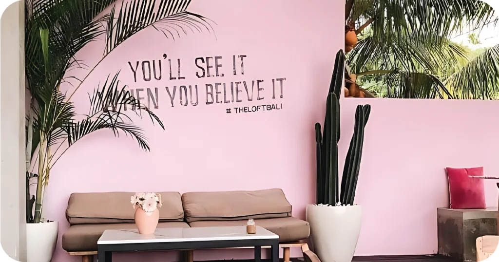 Pink lounge wall with quote and #TheLoftBali branding