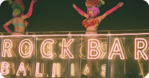 Rock Bar Bali neon sign with costumed performers dancing above