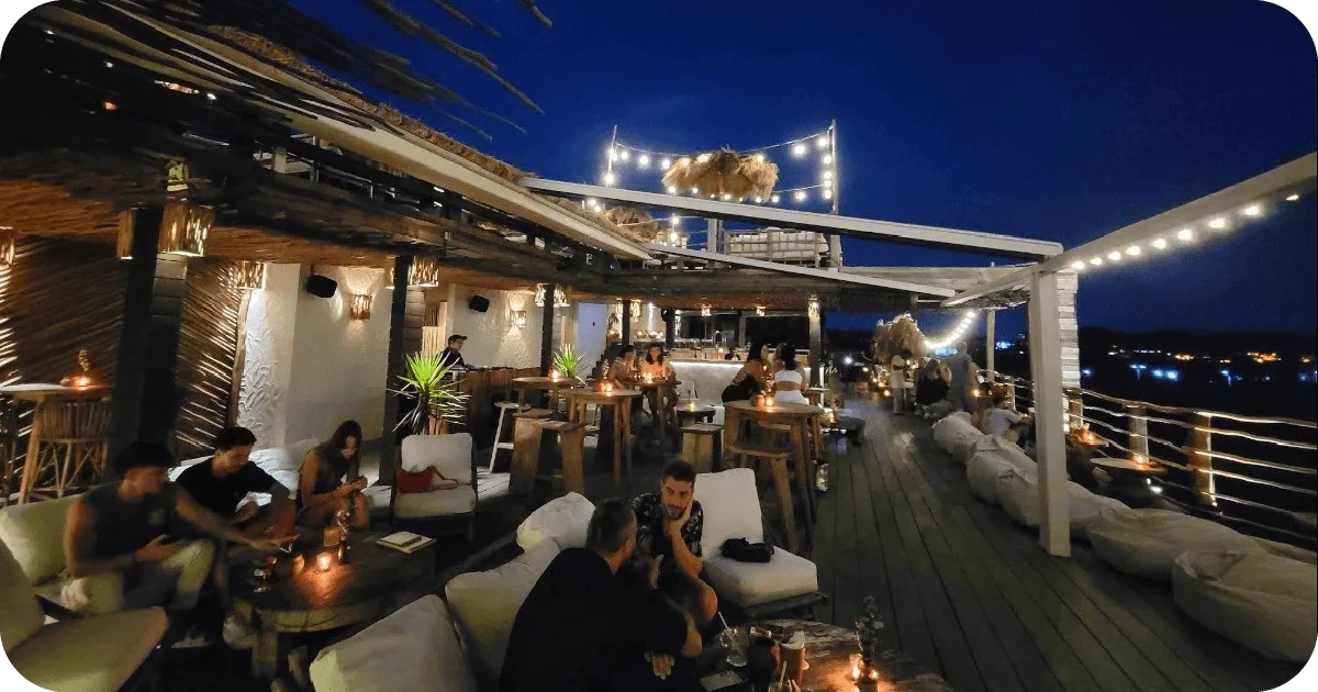 Rooftop bar at night with string lights and lounge seating