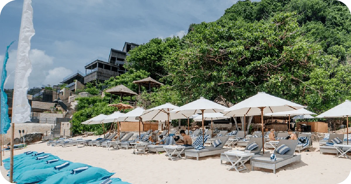 Rows of beach loungers with white umbrellas on sand
