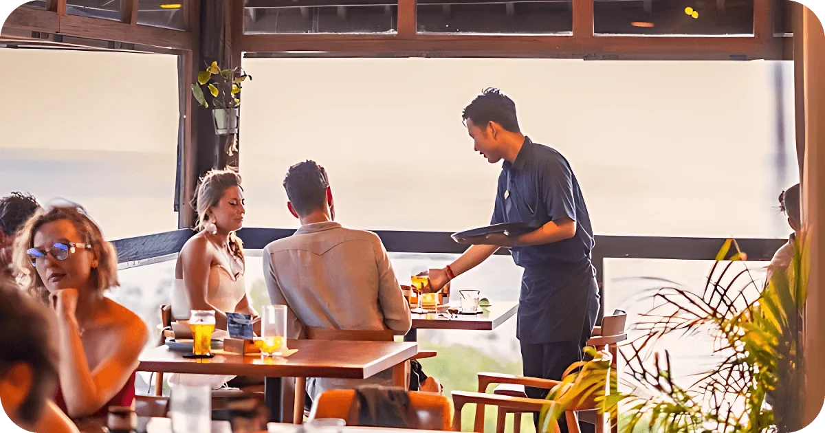 Server delivers drinks to guests at window-side table