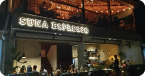 Suka Espresso two-story café with open-air balcony and glowing sign