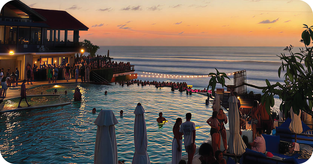 Sunset infinity pool and ocean view beside packed terrace bar