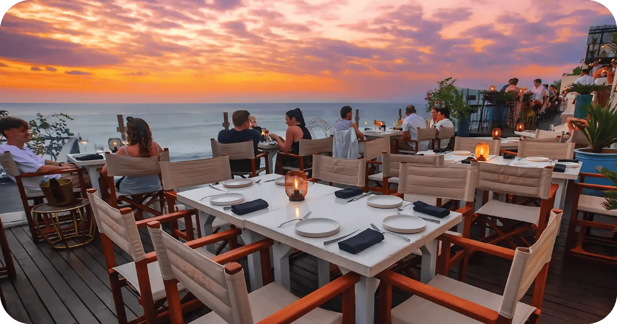 Sunset oceanfront terrace with candlelit tables and canvas director chairs