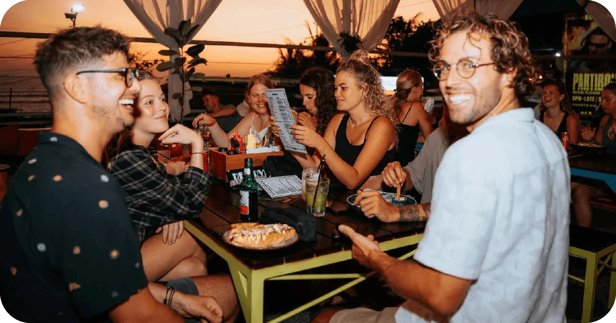 Sunset patio table with cocktails, beer bottles, and menus