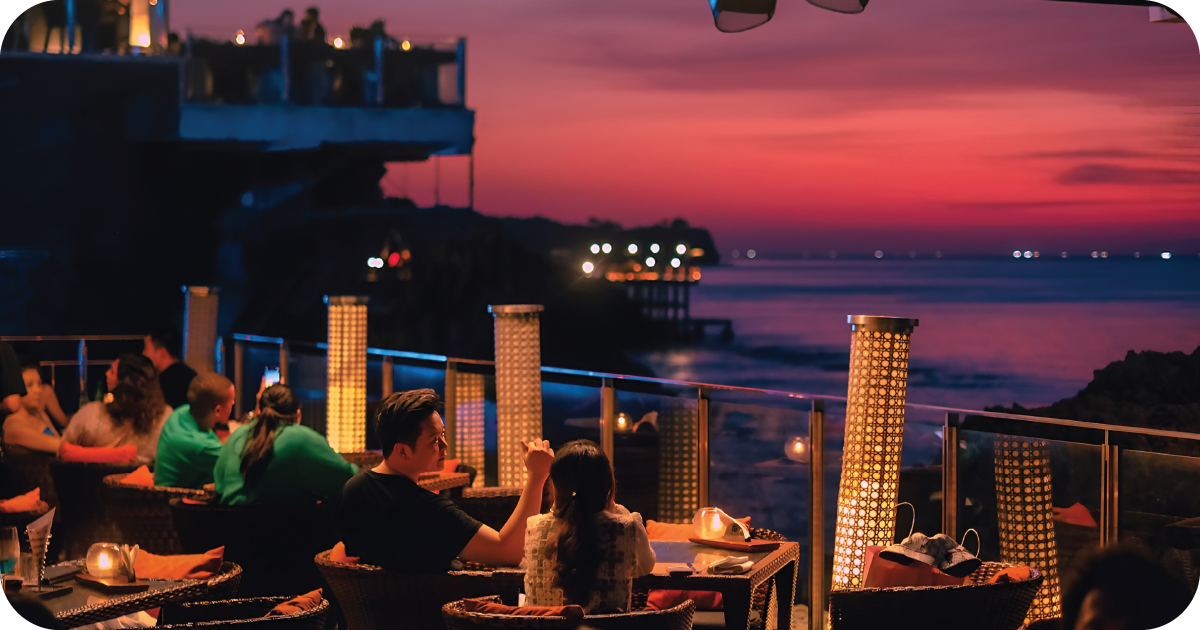 Sunset terrace with lantern-lit tables overlooking the sea